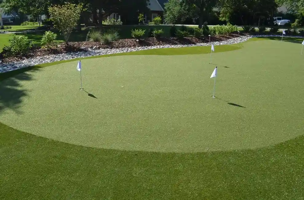 Artificial turf putting green in backyard with golf course setup
