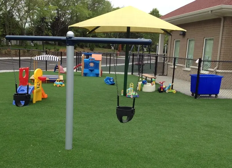 Safe playground turf installed with play equipment in Addison, TX.